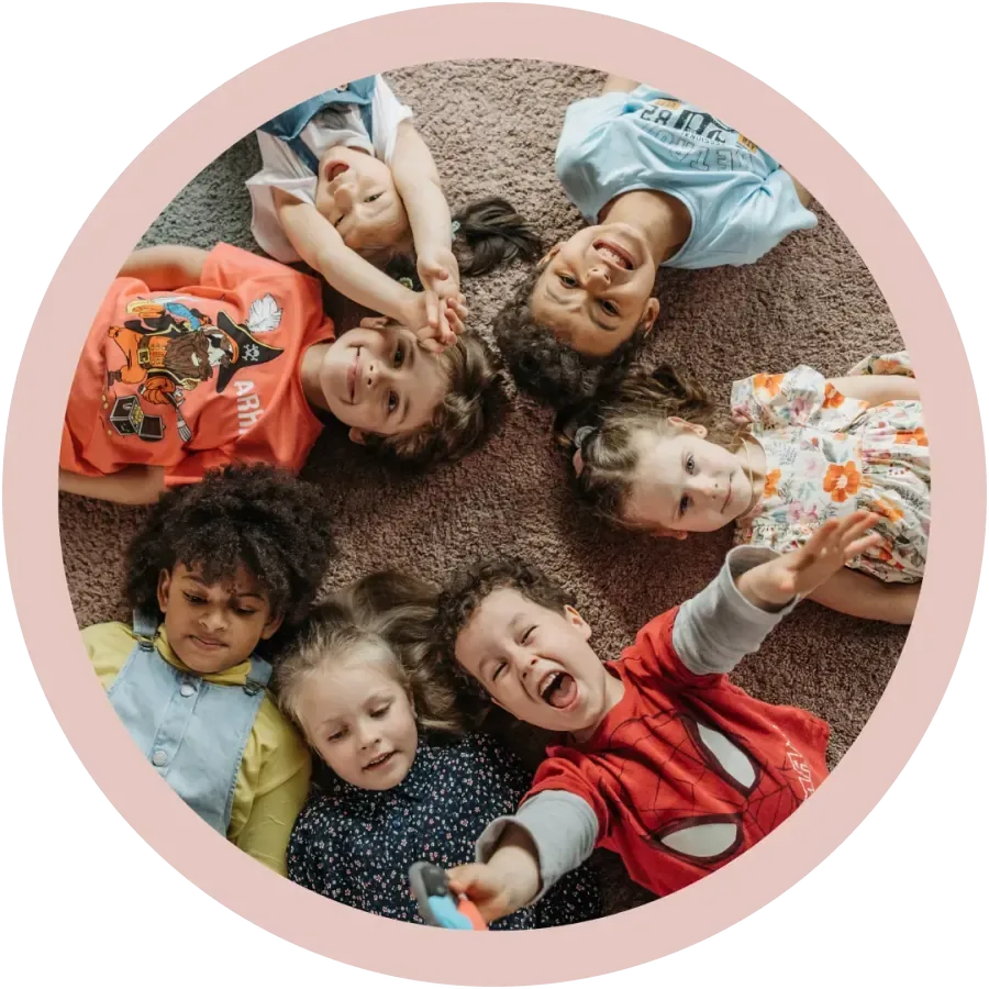 Lachende Kinder liegen gemeinsam im Kreis, Freude und Sicherheit beim Lernen